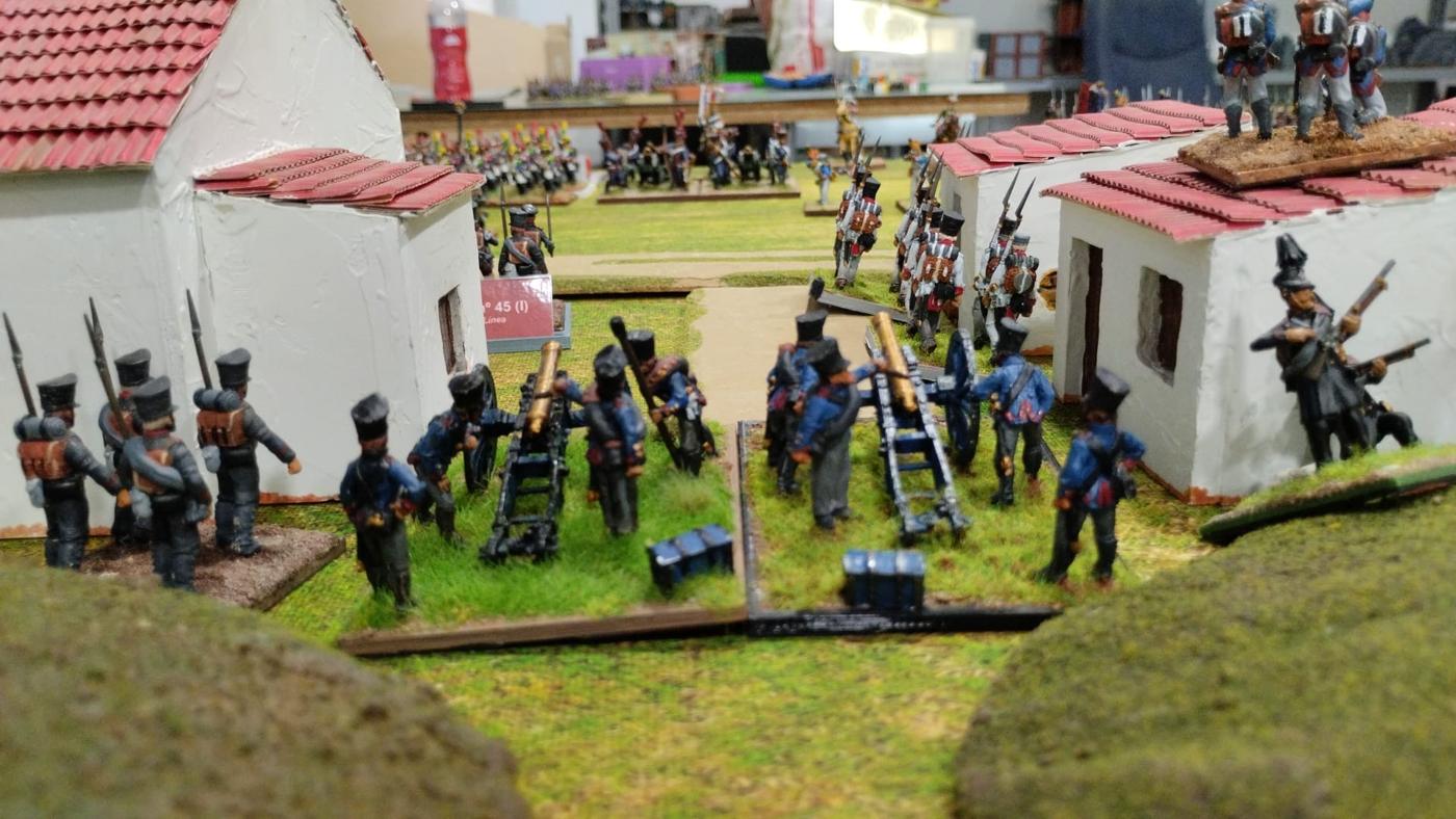 La batería prusiana de 6 libras disparando entre dos casas de Lützeroda, con la línea francesa al fondo